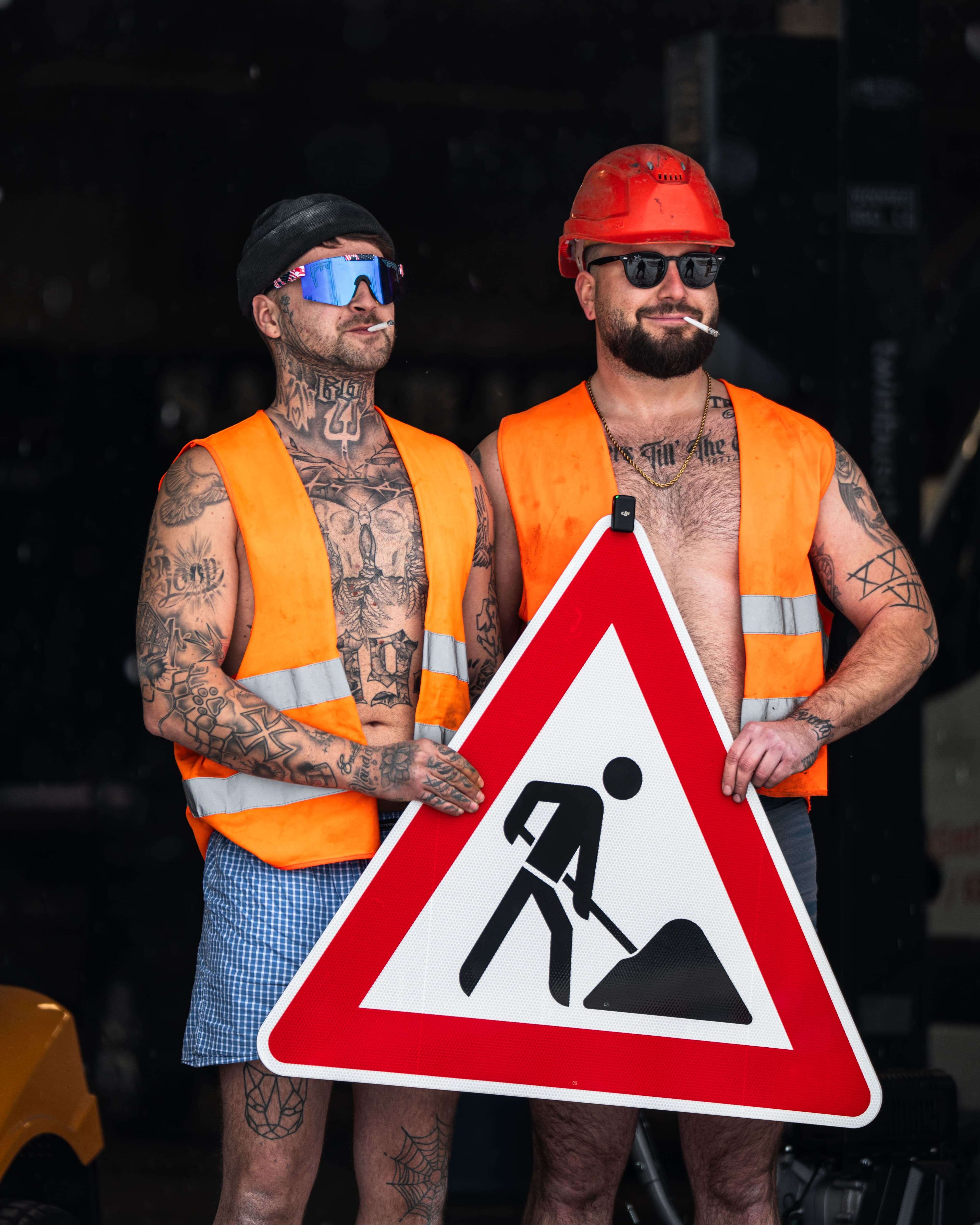 Zwei Bauarbeiter mit Baustellenschild